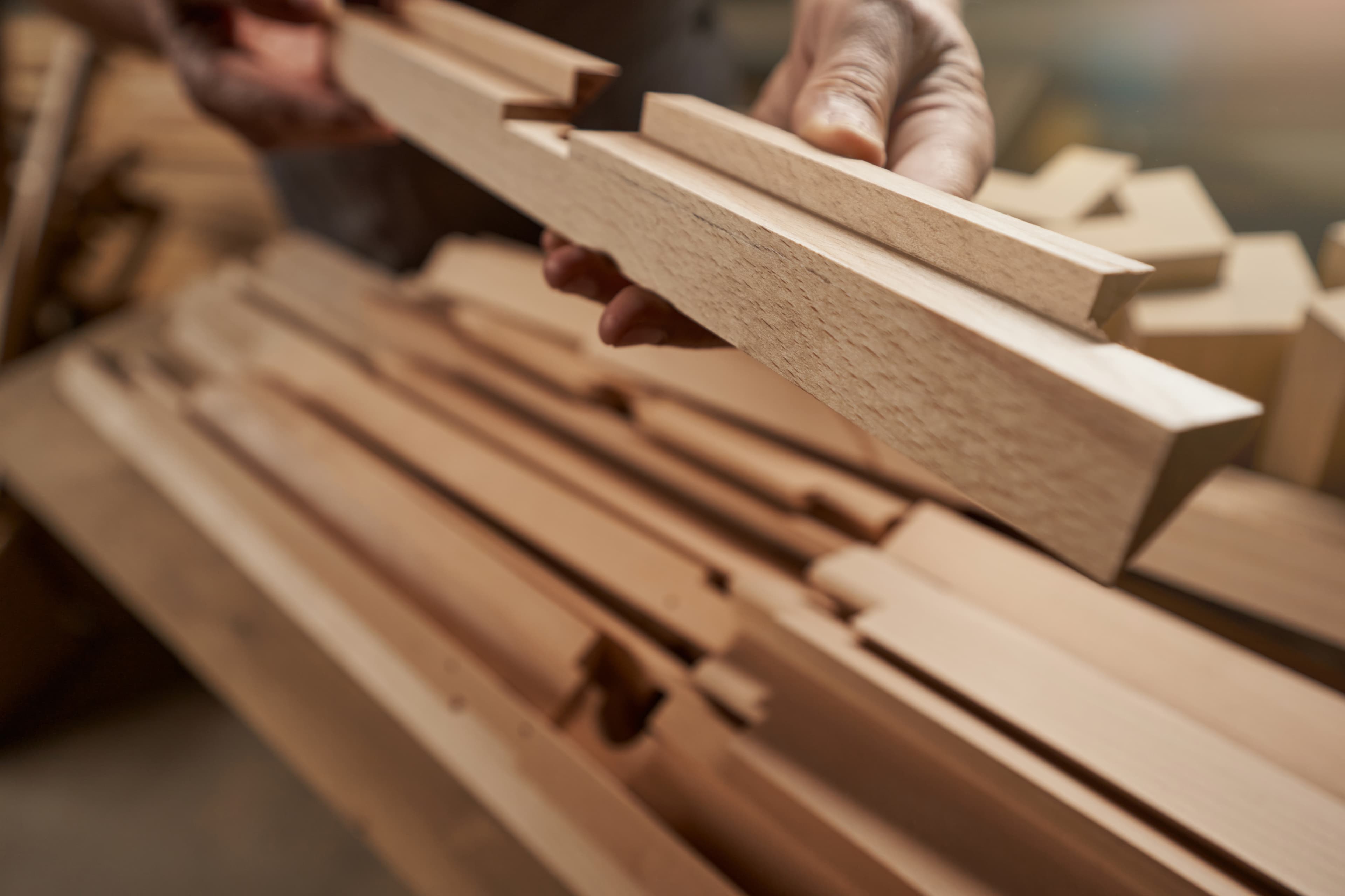 Manos revisando una pieza de madera trabajada.